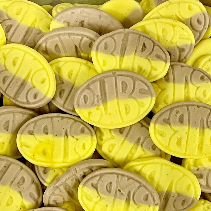 Close-up of BUBS oval candies in yellow and beige with embossed lettering