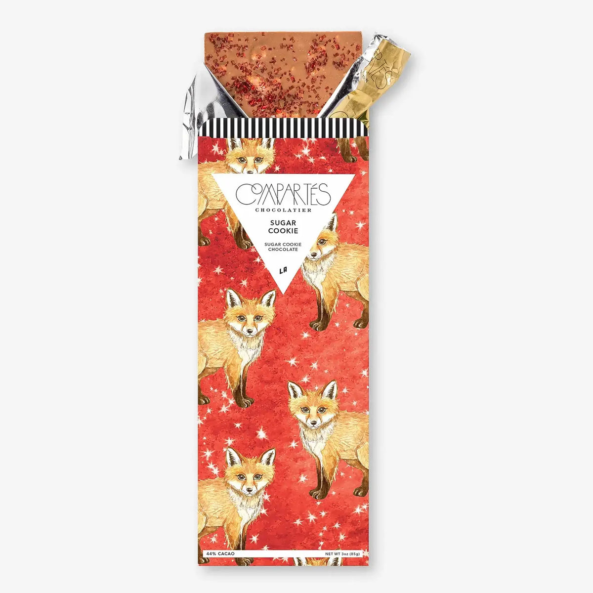 Front view of Compartes Sugar Cookie Chocolate Bar showcasing fox-patterned red packaging and an unwrapped sprinkled chocolate bar on white