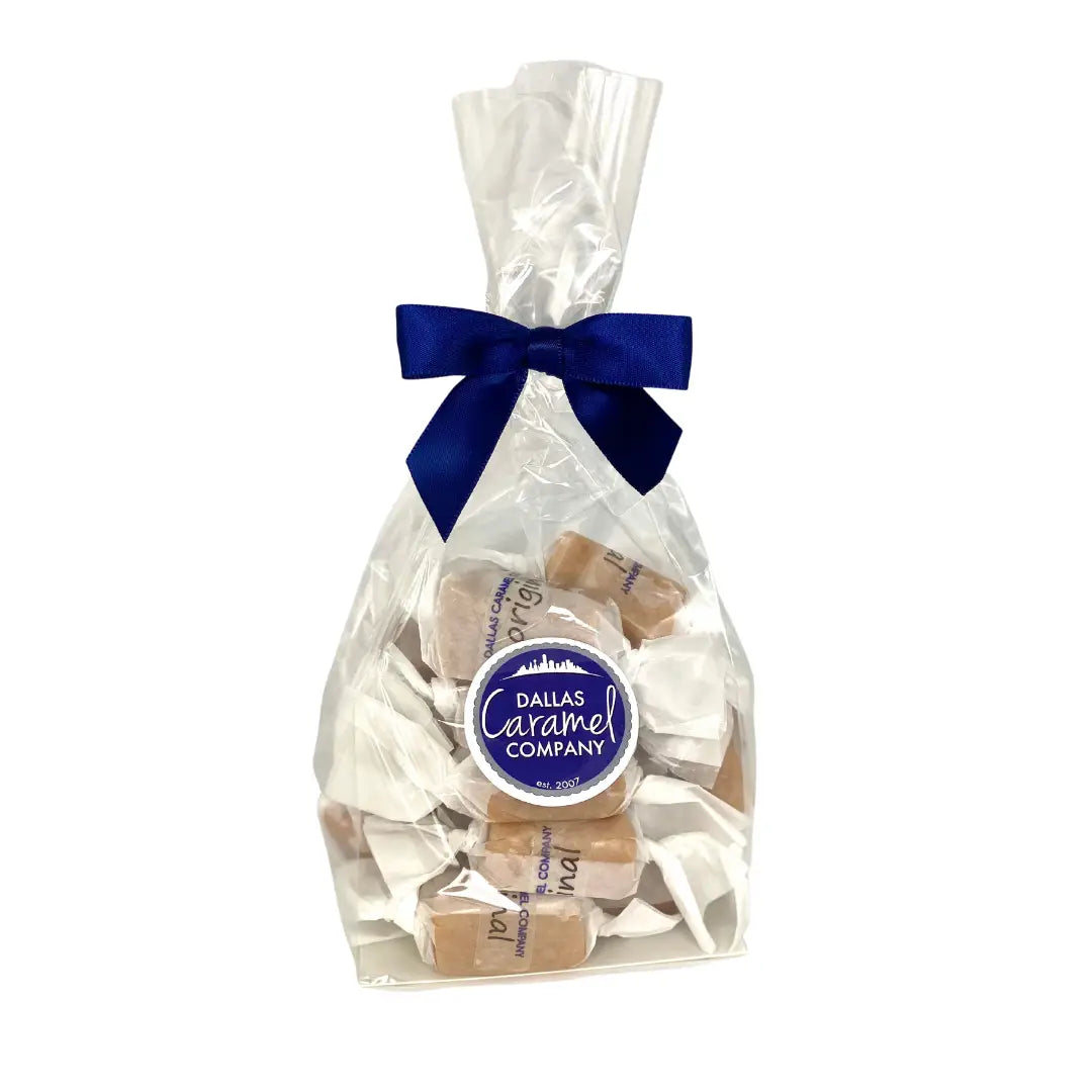 Bag of caramels with a blue bow and Dallas Caramel Company label on a white background