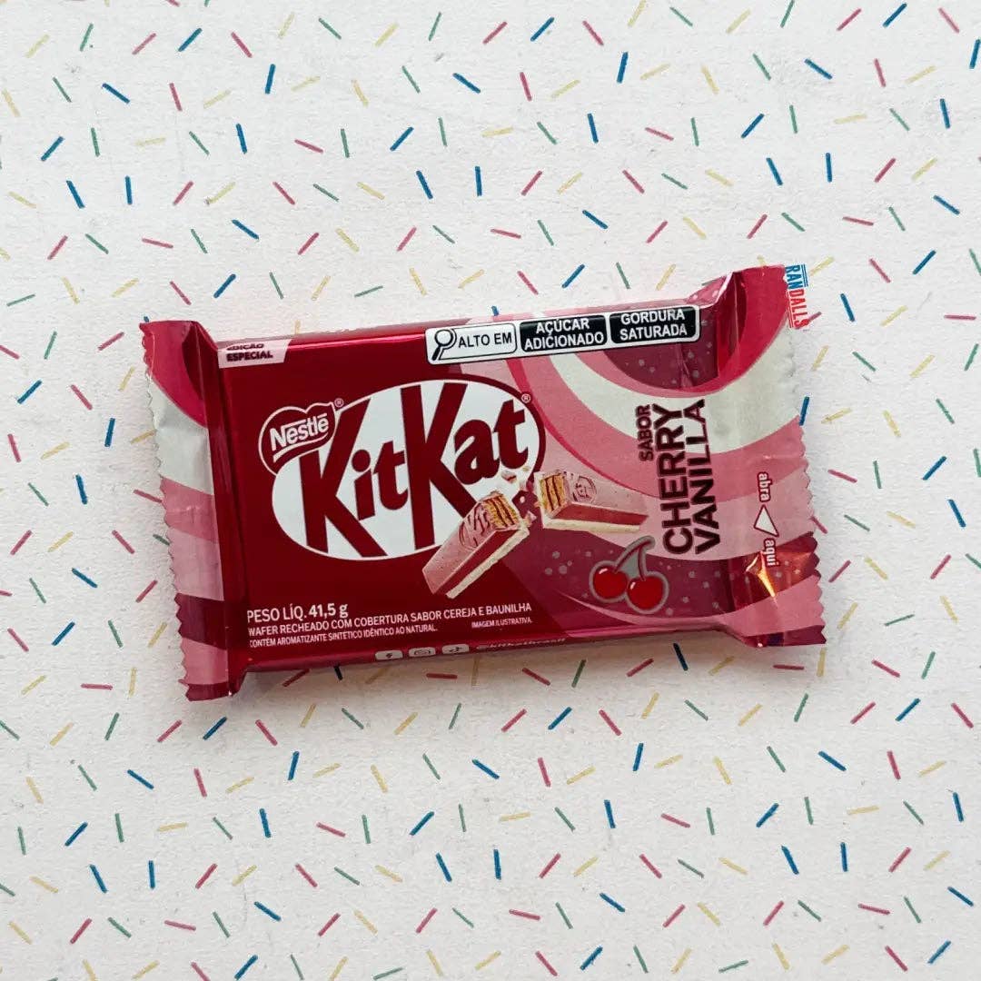 KitKat cherry vanilla chocolate bar packaging on a colorful sprinkles background