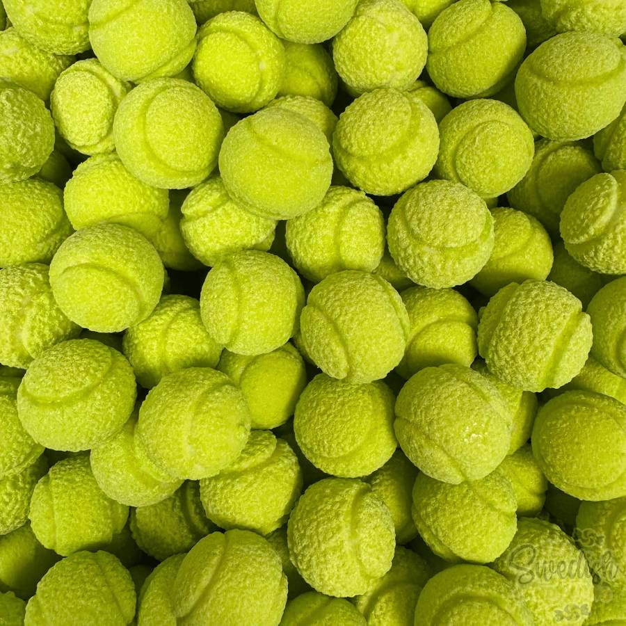 A dense pile of bright yellow-green tennis ball bubblegum filling the frame, with overlapping textured balls visible throughout
