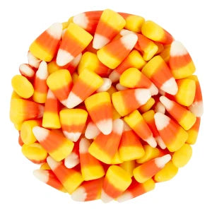 A pile of candy corn pieces arranged in a circular shape on a plain white background